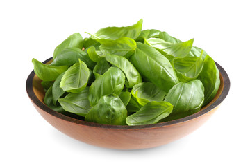 Fresh basil leaves in wooden bowl isolated on white