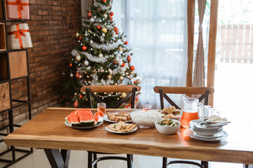 interior of dining room with food and christmas tree inside