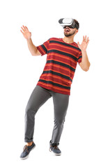 Young man with virtual reality glasses on white background