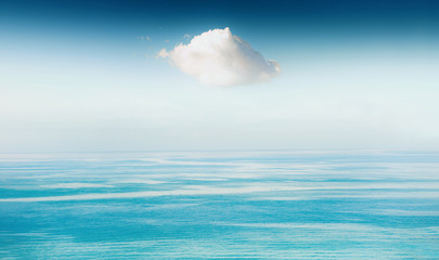 White cloud in the sky over the blue sea. Beautiful seascape, summer nature background.