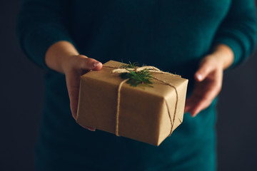 Woman offering wrapped Christmas gift