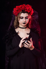 girl witch in a wreath of red roses - 303908928