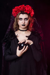girl witch in a wreath of red roses - 303908943