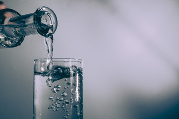 Pouringclear water from bottle into glass.