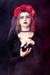 girl witch in a wreath of red roses - 303908995