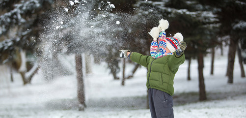 little child play with snow in winter scenery