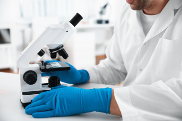 Scientist with modern microscope at table, closeup. Medical research