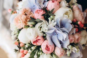 Luxury bridal bouquet with hydrangeas and peony roses. Flowers in a bouquet close-up. delicate wedding bouquet in white and lilac colors.