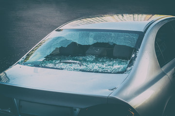 Fototapeta na wymiar Broken rear glass of car, spread fragments of glass on asphalt