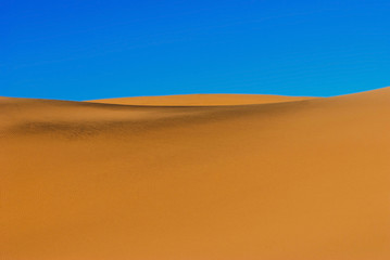 Fototapeta na wymiar Sand dunes against blue sky