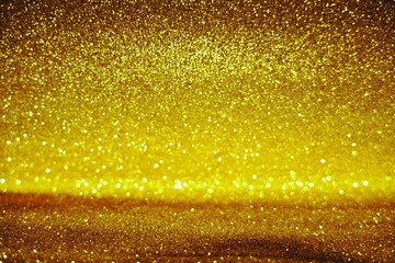 gold Sparkling Lights Festive background with texture. Abstract Christmas twinkled bright bokeh defocused and Falling stars. Winter Card or invitation	