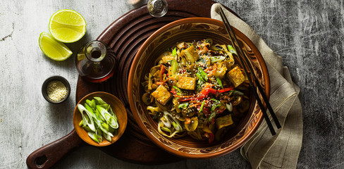 banner of Asian vegan stir fry with tofu, rice noodles and vegetables, top view. - obrazy, fototapety, plakaty