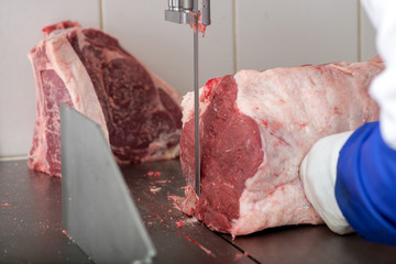 band saw cuts meat in a meat shop