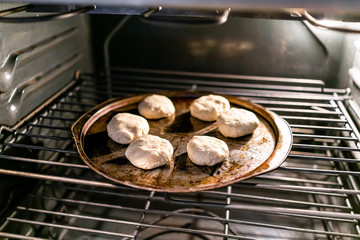 Baking pan with uncooked raw dough for biscuits or scones baking made with gluten free flour inside oven
