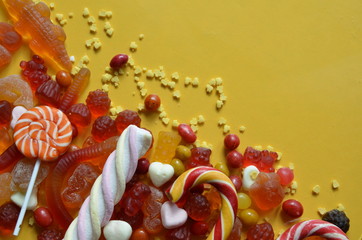 candies with jelly and sugar. colorful array of different childs sweets and treats red marmalade in the shape of a heart with a variety of caramels, marshmallows. Abstract. top view copy space