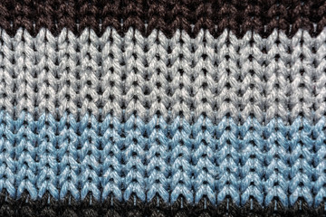 Texture of knitted fabric. Stranded threads. Cloth of warm winter clothes. Warm blanket. The texture of the blue gray and black threads. Background.