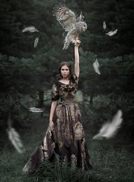 Fairytale photo of a warrior girl with an owl on an outstretched arm