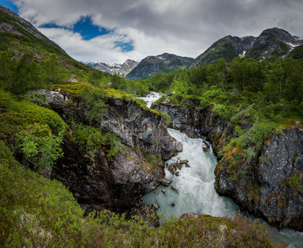 Intens green and lush mountain valley landscape with glacial river in Austerdalen Norway