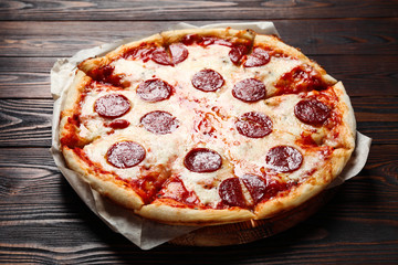 Hot delicious pepperoni pizza on wooden table