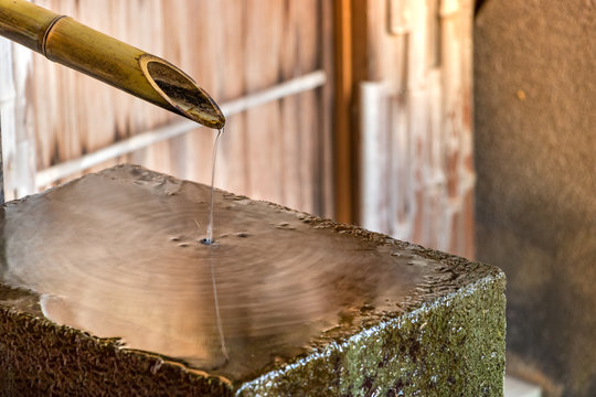 A chozubachi - cho zu, a bamboo pipe dropping water on a flat stone, Kanazawa, Japan.