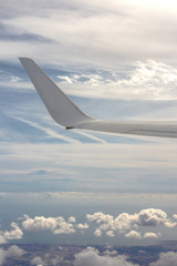 Obraz premium Clouds in the sky behind the wing of an airplane