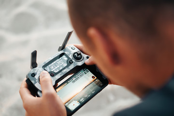 Young man are holding his drone controller in army skin. © Nataly