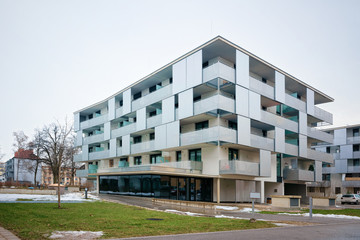 Modern residential apartment and flat buildings exterior in Salzburg, in Austria. New luxury house and home complex. City Real estate property and condo architecture. Snow in the street on background