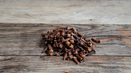 Dried clove seasoning on old wooden boards. Products in the kitchen in the village.