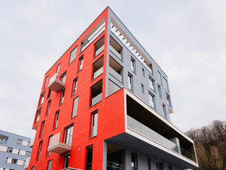 Colorful Modern residential apartment and flat building exterior in Salzburg, in Austria. New luxury house and home complex of red color. City Real estate property and condo architecture.