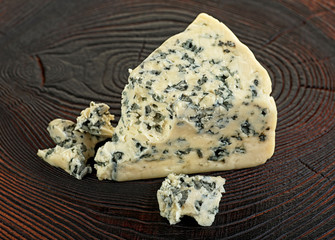 Slices of blue cheese on wooden table, selective focus.
