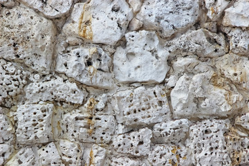 Wall made of naturally perforated stones