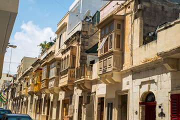 Fototapeta na wymiar Sliema Malta, July 16 2019. Traditional Maltese architecture in Sliema Old Town in Malta, street with traditional balconies and old buildings in historical city of Malta.