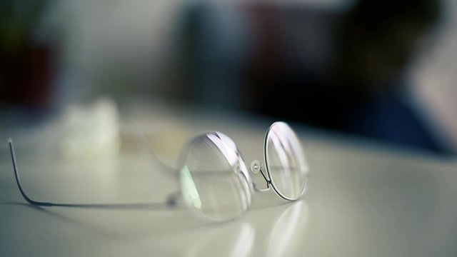 Slow motion over modern titanium eyewear glasses on the table 