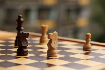 wooden pieces, chess horses, white and dark brown on a chessboard, game concept