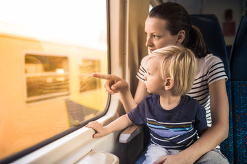 Mother and child riding on train together. Parenting and teaching your  kids concept. 