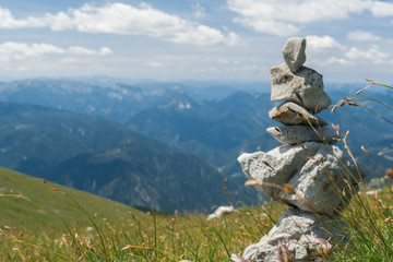 mountain landscape with blue sky and clouds and rock statue in foreground