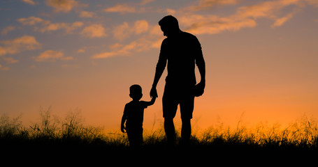 Loving father walking side by side with son holding hands.  - obrazy, fototapety, plakaty
