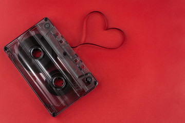 vintage old film music cassette on a trendy pink red background with film heart shaped, background music, music lovers