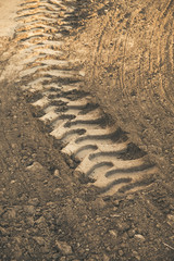 Fototapeta na wymiar Excavator tire tracks embedded in the soil