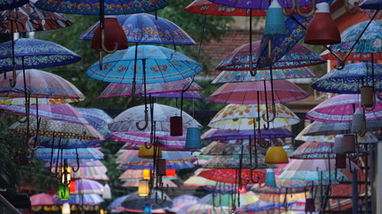 Fototapeta na wymiar Colorful umbrellas hanging from the buildings