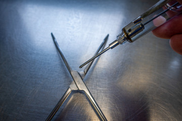 The joint of a surgical instrument is oiled with an oil syringe.