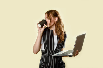 A young girl in a shirt with a Cup of coffee and a tablet in her hands. Girl in glasses smiles.