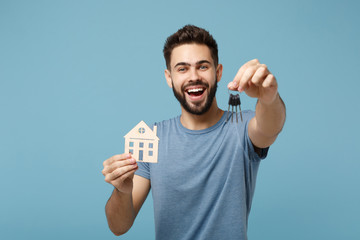 Young laughing man in casual clothes posing isolated on blue wall background, studio portrait....