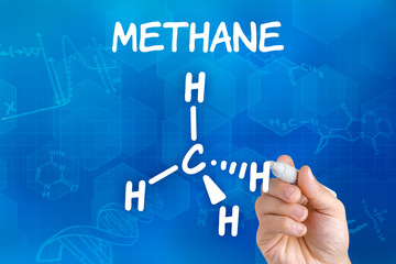Hand with pen drawing the chemical formula of methane