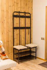 Iron shoe rack with clothes hooks at the front door.