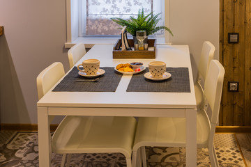Modern kitchen table with tea and cookies.