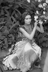 Fototapeta na wymiar stunning black and white portrait beautiful young model girl in arranger where azalea blooms in a flying dress. Beauty and Fashion