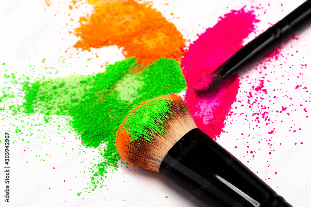 Wall mural cheek brush with neon cosmetic powder colorful pile on white background