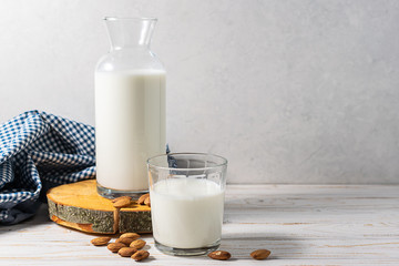 Organic non dairy almond milk in a glass bottle and glass of almond milk on the table. Healthy eating concept. Healthy and organic food concept.