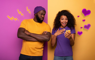 Girl receive a lot of hearths on social and boy is jealous about it. Yellow and violet background - obrazy, fototapety, plakaty
